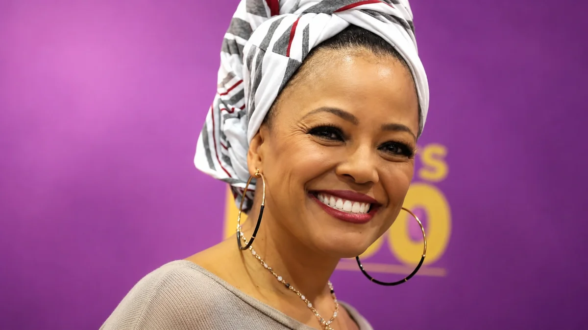 Kim Fields smiling while wearing a patterned headwrap and hoop earrings during a public appearance for Kim Fields Net Worth early life