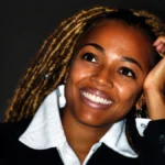 Kim Fields smiling in a black blazer and white shirt for Kim Fields Net Worth