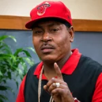 Trick Daddy at a public appearance wearing a red cap and black shirt for the Trick Daddy Net Worth