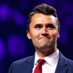 Charlie Kirk Net Worth portrait showing Charlie Kirk in a suit at a public event.