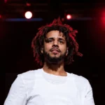 J Cole performing live on stage during a concert, highlighting J Cole Net Worth, music career, earnings, and financial success.