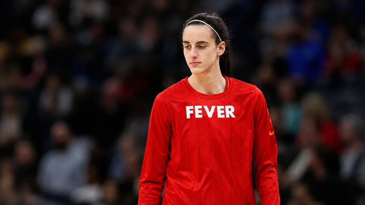 Caitlin Clark Early Life – basketball star wearing a red Fever warmup shirt during her basketball career.