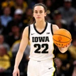 Caitlin Clark Net Worth – Iowa basketball player holding a basketball during her college career.