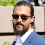 Matthew McConaughey Net Worth portrait wearing sunglasses and a blue suit