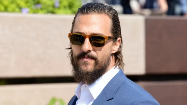 Matthew McConaughey Net Worth portrait wearing sunglasses and a blue suit