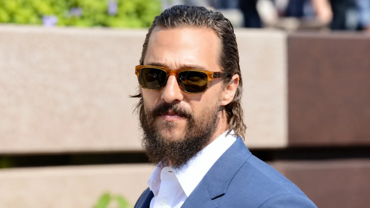 Matthew McConaughey Net Worth portrait wearing sunglasses and a blue suit