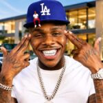 DaBaby Net Worth showing the rapper surrounded by cash, jewelry, and luxury lifestyle elements.